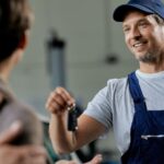 Autosleutel bijmaken door monteur die sleutel overhandigt aan klant in werkplaats