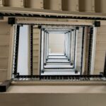 Zwarte stalen leuningen rondom een trapschacht met meerdere verdiepingen