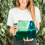 Een vrouw heeft cadeaus vast voor een groene struik